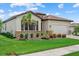 Well-maintained home with lush landscaping, a brick driveway, and a two-car garage at 11970 Lovegrass St, Venice, FL 34293