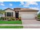 Beautiful single-story home with a tile roof, manicured lawn, and brick driveway at 11970 Lovegrass St, Venice, FL 34293