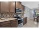 Modern kitchen featuring wood cabinets, stainless steel appliances, and tile backsplash at 11970 Lovegrass St, Venice, FL 34293