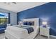 Comfortable main bedroom with a white bed, blue accents, and access to the outdoors at 11970 Lovegrass St, Venice, FL 34293