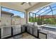 Outdoor kitchen under lanai overlooking pool and lush greenery at 11970 Lovegrass St, Venice, FL 34293