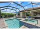 Relaxing screened-in pool area featuring a pool, spa and outdoor seating under a clear blue sky at 11970 Lovegrass St, Venice, FL 34293