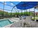 Screened in pool area with patio furniture and lush landscaping offering a private backyard retreat at 11970 Lovegrass St, Venice, FL 34293