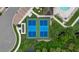 Overhead view of the bright blue community tennis courts nestled amid green trees, providing a scenic recreational space at 11970 Lovegrass St, Venice, FL 34293