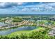 An expansive aerial shot shows the community nestled around a golf course and shimmering lakes at 1210 Eagles Flight Way, North Port, FL 34287