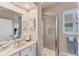 Updated bathroom with glass shower, neutral tiling, sink with vanity and a bright window at 1210 Eagles Flight Way, North Port, FL 34287