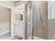 Bathroom with tiled walk-in shower featuring a glass door and sink with white vanity at 1210 Eagles Flight Way, North Port, FL 34287