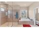Bathroom featuring a walk-in shower, a separate tub, and a large window at 1210 Eagles Flight Way, North Port, FL 34287
