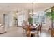Elegant dining area with a wooden table, chandelier, and open access to other rooms at 1210 Eagles Flight Way, North Port, FL 34287