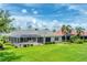 Exterior of house with a screened-in pool and lush green backyard at 1210 Eagles Flight Way, North Port, FL 34287