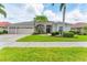 Inviting single-story home with well-maintained landscaping, a three-car garage, and a welcoming entrance at 1210 Eagles Flight Way, North Port, FL 34287