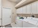 Laundry room featuring a large washer and dryer, cabinetry, and utility sink at 1210 Eagles Flight Way, North Port, FL 34287