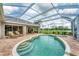 The screened-in pool area offers comfortable seating and views of the lake at 1210 Eagles Flight Way, North Port, FL 34287