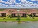 Aerial view of condos in a circle around a scenic pond in a lush green space at 12590 Ghiberti Cir # 201, Venice, FL 34293