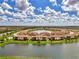 Beautiful aerial view of condos surrounding a central lake under a partly cloudy blue sky at 12590 Ghiberti Cir # 201, Venice, FL 34293