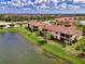 Aerial view of condos surrounded by lush green spaces, trees, and a scenic pond at 12590 Ghiberti Cir # 201, Venice, FL 34293