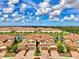 Stunning aerial of townhomes near a scenic lake, showcasing beautiful landscaping and design at 12590 Ghiberti Cir # 201, Venice, FL 34293