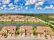 Panoramic aerial shot of tan townhomes with red tile roofs surrounding a picturesque lake at 12590 Ghiberti Cir # 201, Venice, FL 34293