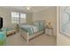 Cozy bedroom with a white and aqua color palette, and natural light from the window at 12590 Ghiberti Cir # 201, Venice, FL 34293
