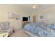 Inviting bedroom features a patterned duvet, accent chair, and convenient ensuite access at 12590 Ghiberti Cir # 201, Venice, FL 34293