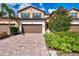 Inviting townhome featuring lush landscaping, brick drive, and a convenient attached garage at 12590 Ghiberti Cir # 201, Venice, FL 34293