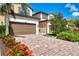 Attractive townhome displaying colorful flower beds, brick driveway, and an attached garage at 12590 Ghiberti Cir # 201, Venice, FL 34293