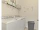 Well-lit laundry room with modern white washer and dryer units and decorative accents at 12590 Ghiberti Cir # 201, Venice, FL 34293