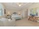 This main bedroom features a tray ceiling, plantation shutters, a seating area, and stylish decor at 12590 Ghiberti Cir # 201, Venice, FL 34293
