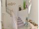 Bright staircase with carpeted steps and white wooden railing and coastal decorations at 12590 Ghiberti Cir # 201, Venice, FL 34293