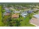 Overhead shot of the home surrounded by green lawns, trees, and neighboring properties in a suburban setting at 1315 Pine Needle Rd, Venice, FL 34285