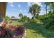 A serene backyard featuring lush greenery, rock borders, and mature trees, creating a private oasis at 1315 Pine Needle Rd, Venice, FL 34285