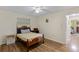 Cozy bedroom featuring hardwood floors, a ceiling fan, and natural light from a window at 1315 Pine Needle Rd, Venice, FL 34285