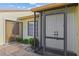Close-up of the screened front entryway featuring double doors and side window with a stone-paved porch at 1315 Pine Needle Rd, Venice, FL 34285