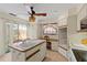 Bright kitchen featuring a peninsula island, a ceiling fan, and a sliding glass door to the outdoors at 1315 Pine Needle Rd, Venice, FL 34285