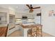 Bright kitchen featuring an island, tiled backsplash, and white cabinets with a ceiling fan at 1315 Pine Needle Rd, Venice, FL 34285