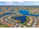 Breathtaking aerial view of a Primary-planned community featuring beautiful homes, winding roads, and sparkling lakes at 13334 Pacchio St, Venice, FL 34293