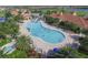 Aerial view of the uniquely shaped pool, amenity center, and lush landscaping at 13334 Pacchio St, Venice, FL 34293