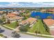 Expansive lakefront community featuring homes with tile roofs, lush greenery, and a charming bridge at 13334 Pacchio St, Venice, FL 34293