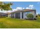 Green backyard featuring a covered patio, privacy shrubs, and a well maintained lawn at 13334 Pacchio St, Venice, FL 34293