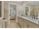 Elegant bathroom featuring double sinks, marble countertops, and a view into the bright and airy bedroom at 13334 Pacchio St, Venice, FL 34293