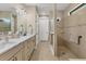 Modern bathroom featuring a double vanity with marble countertops and a separate walk-in shower with neutral tile at 13334 Pacchio St, Venice, FL 34293
