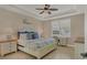 Serene bedroom featuring tray ceiling, plush bedding, and a cozy window nook, creating a relaxing retreat at 13334 Pacchio St, Venice, FL 34293