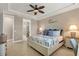 Tranquil bedroom with a decorative ceiling fan, coastal-themed decor, and a view into the en-suite bathroom at 13334 Pacchio St, Venice, FL 34293