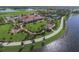 Aerial view featuring community amenities including a pool, clubhouse, fire pit, and walkway by the lake at 13334 Pacchio St, Venice, FL 34293