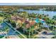 Aerial view of the community pool and clubhouse, surrounded by palm trees and overlooking a lake at 13334 Pacchio St, Venice, FL 34293