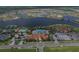 Aerial view of a community pool with tennis courts and a large clubhouse, surrounded by lakes at 13334 Pacchio St, Venice, FL 34293