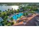Overhead view of a resort-style community pool and amenity center surrounded by palm trees and lush landscaping at 13334 Pacchio St, Venice, FL 34293
