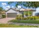 Beautiful home with a tile roof, stone accents, mature landscaping, and a brick driveway at 13334 Pacchio St, Venice, FL 34293