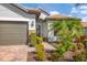 Close-up of a home's facade showcasing a tile roof, stone accents, and lush landscaping at 13334 Pacchio St, Venice, FL 34293