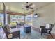 Screened lanai features wicker seating, ceiling fans, outdoor television, and views of lush scenery and a lake at 13334 Pacchio St, Venice, FL 34293